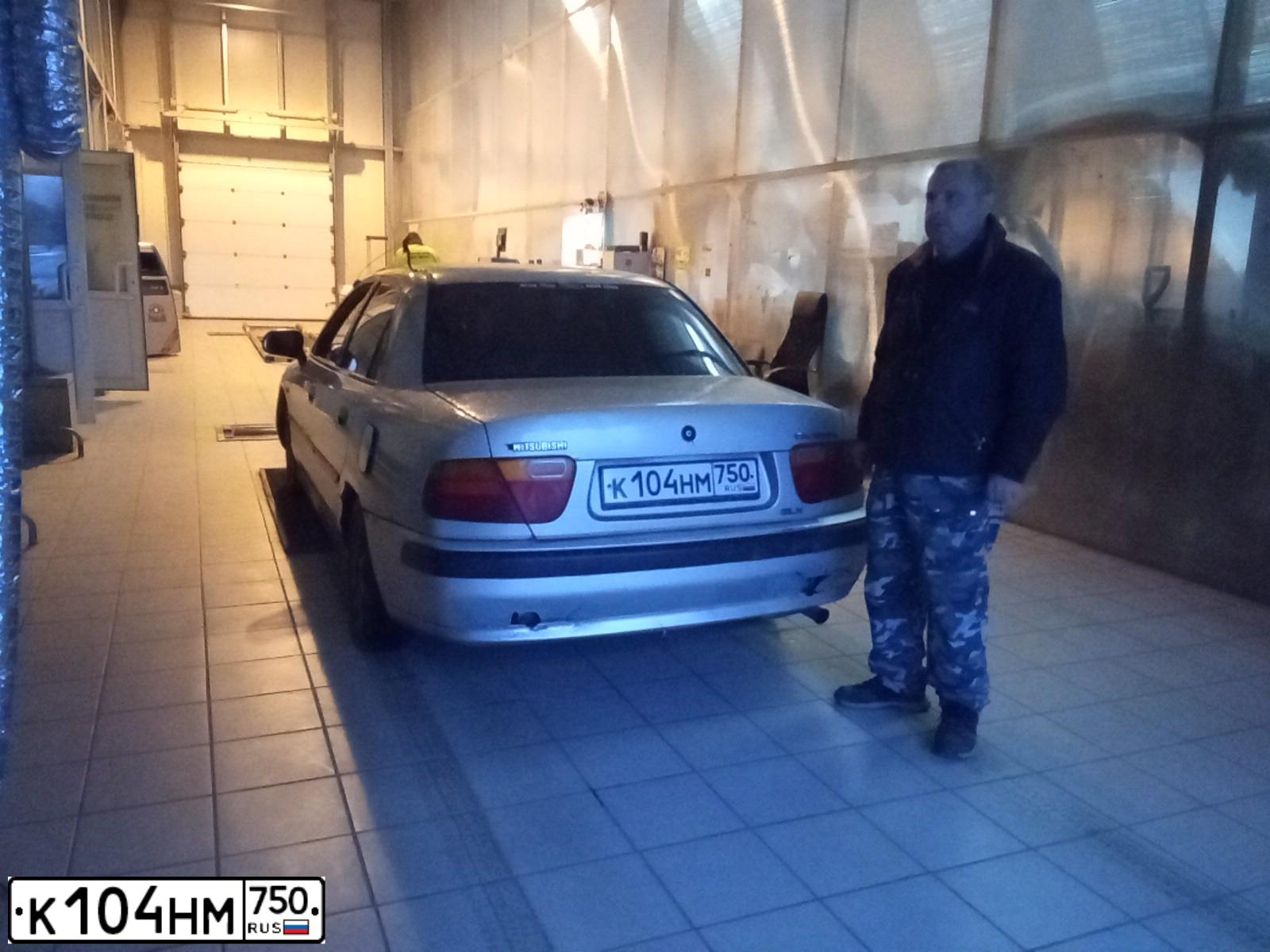 Фото автомобиля MITSUBISHI CARISMA, 1998 — госномер Х127МО77. Цвет: БЕЛЫЙ СЕРЫЙ