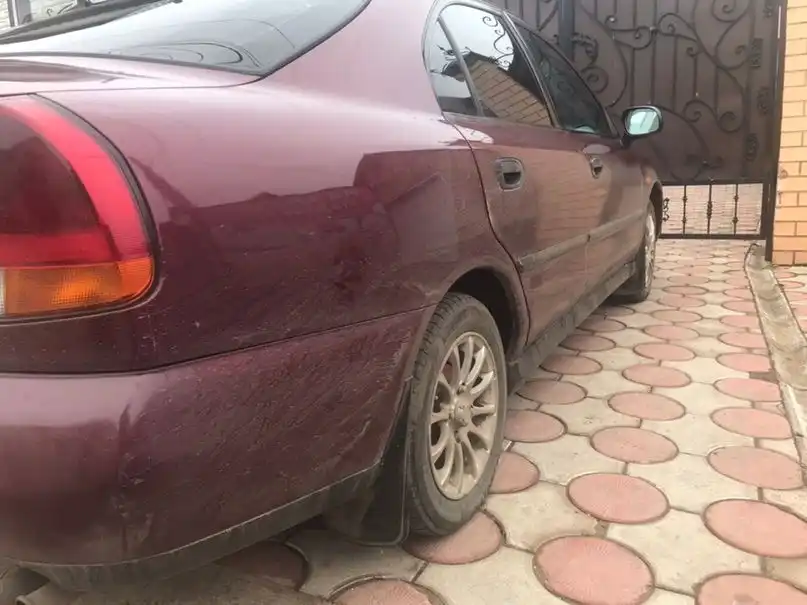 Фото автомобиля MITSUBISHI CARISMA, 1999 — госномер О496НТ102. Цвет: Красный (вишневый)