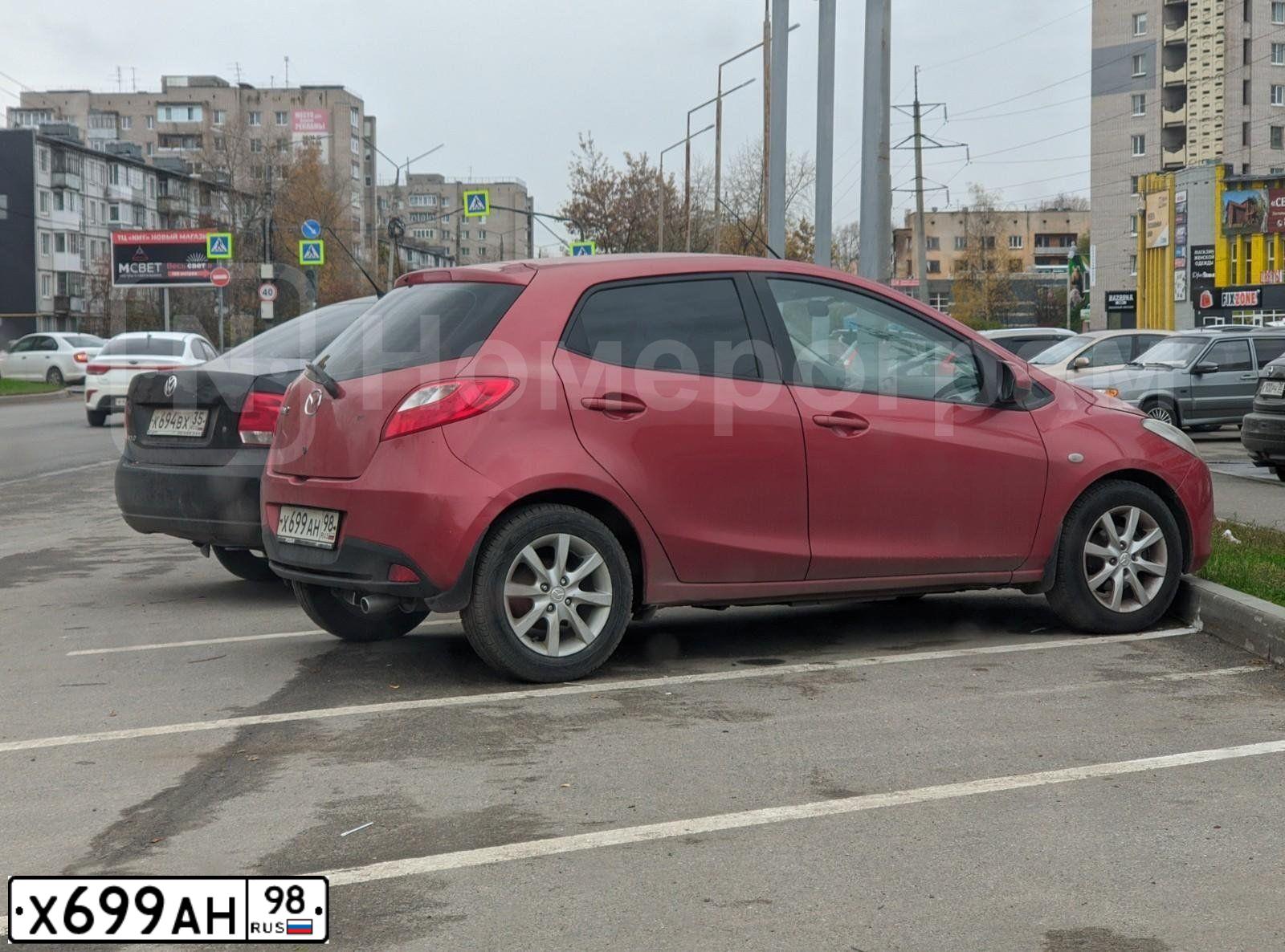 Фото автомобиля MAZDA 2, 2008 — госномер Х699АН98. Цвет: Красный