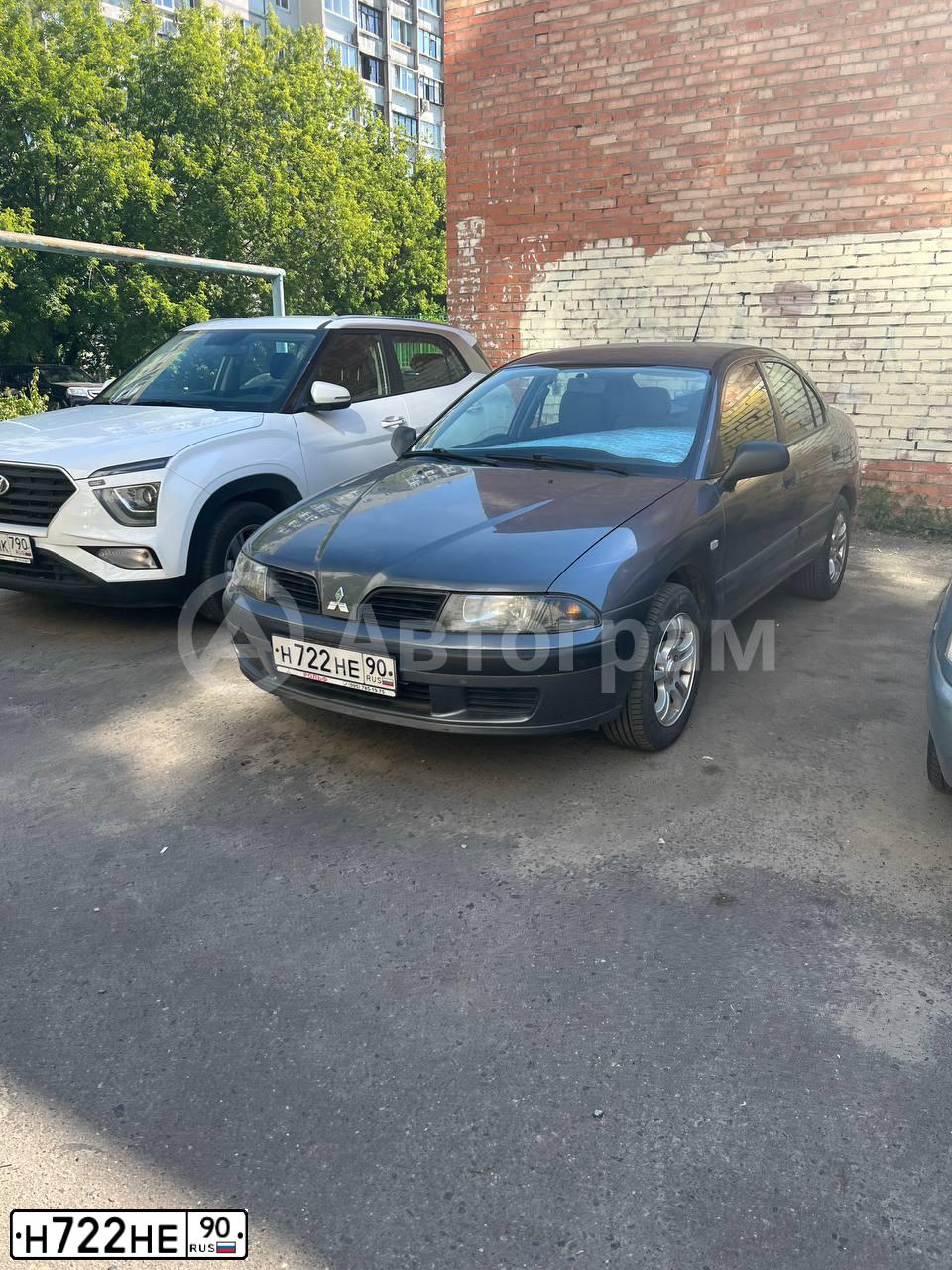 Фото автомобиля MITSUBISHI CARISMA, 2003 — госномер Н722НЕ90. Цвет: СЕРЫЙ