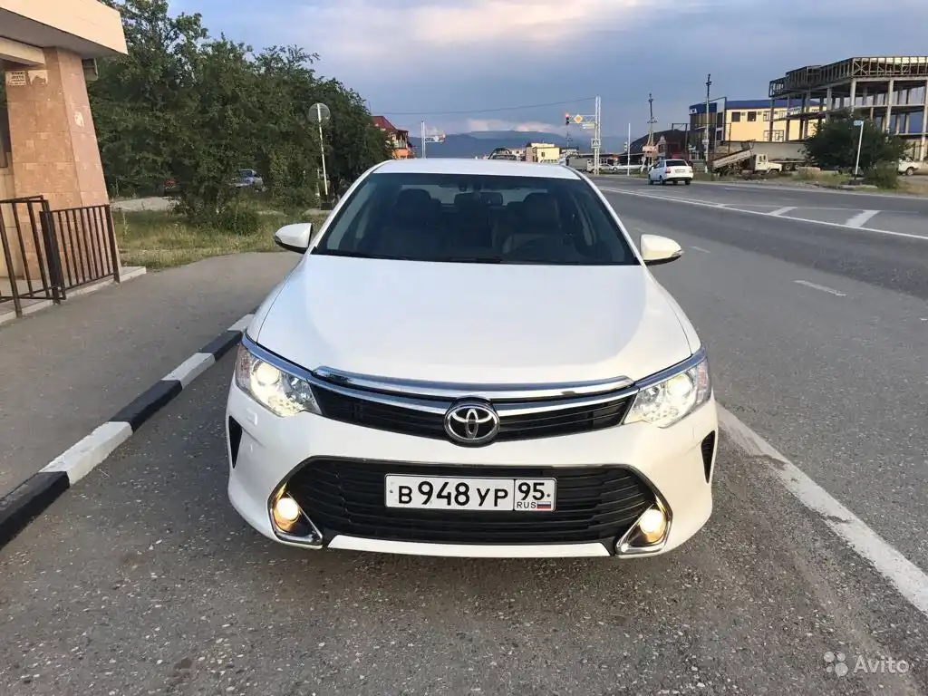 Фото автомобиля TOYOTA CAMRY, 2016 — госномер У095УЕ05. Цвет: БЕЛЫЙ ПЕРЛАМУТР