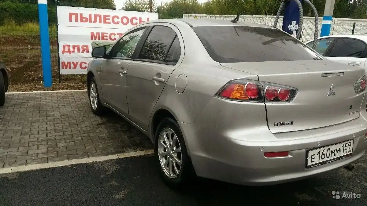 Фото автомобиля MITSUBISHI LANCER, 2013 — госномер О047АА702. Цвет: СЕРЕБРИСТЫЙ