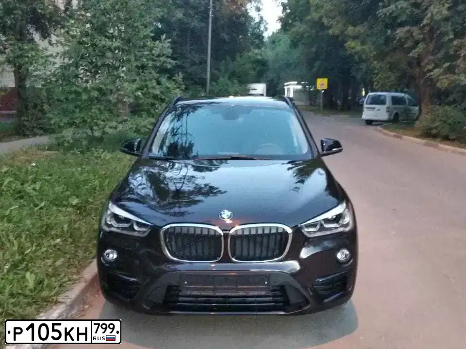 Фото автомобиля BMW X1, 2018 — госномер Р105КН799. Цвет: Коричневый