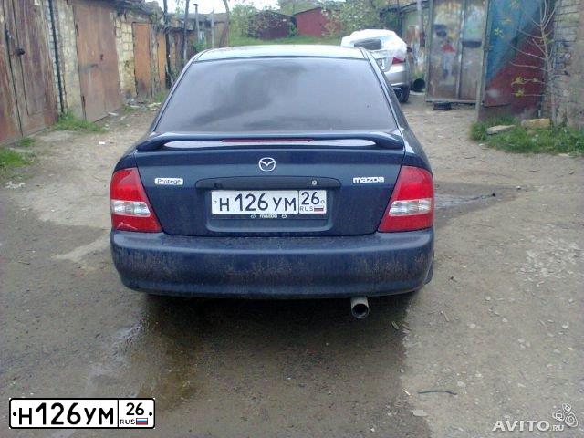 Фото автомобиля MAZDA PROTEGE, 2000 — госномер Х437МК55. Цвет: синий