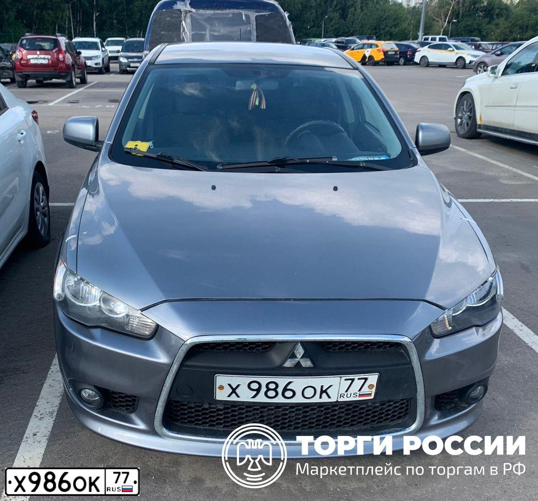 Фото автомобиля MITSUBISHI LANCER, 2013 — госномер Х986ОК77. Цвет: СЕРЫЙ