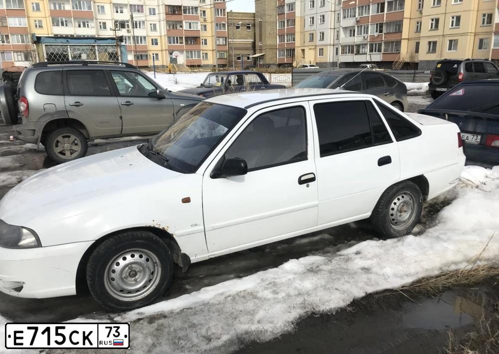 Фото автомобиля DAEWOO NEXIA, 2012 — госномер Е715СК73. Цвет: БЕЛО-ДЫМЧАТЫЙ