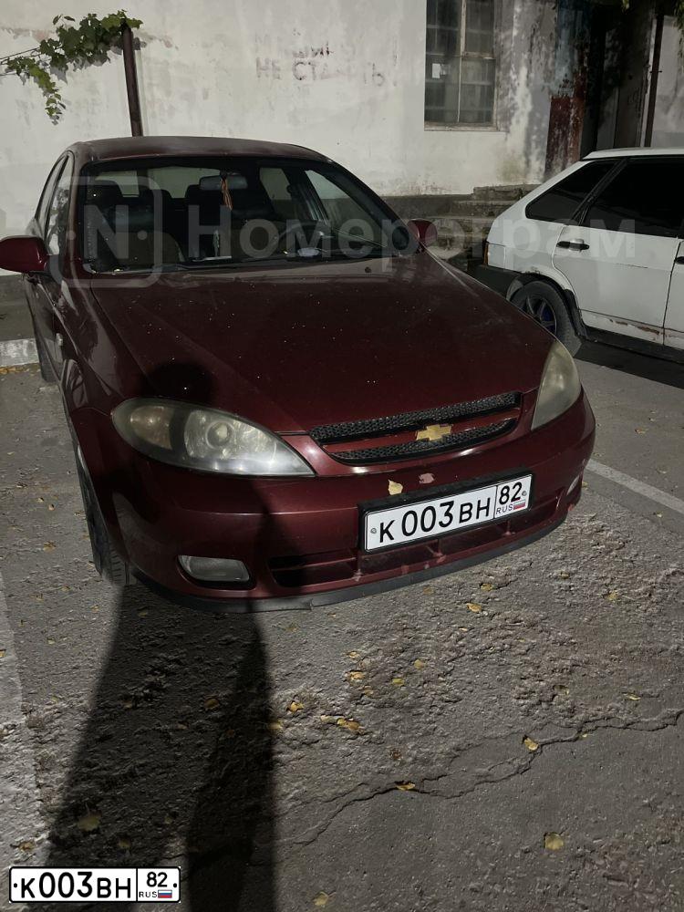 Фото автомобиля CHEVROLET LACETTI, 2005 — госномер К003ВН82. Цвет: ТЕМНО-КРАСНЫЙ