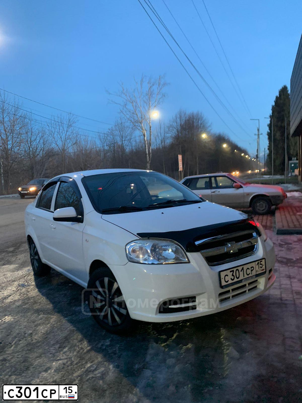 Фото автомобиля CHEVROLET AVEO, 2011 — госномер М111ММ15. Цвет: Белый