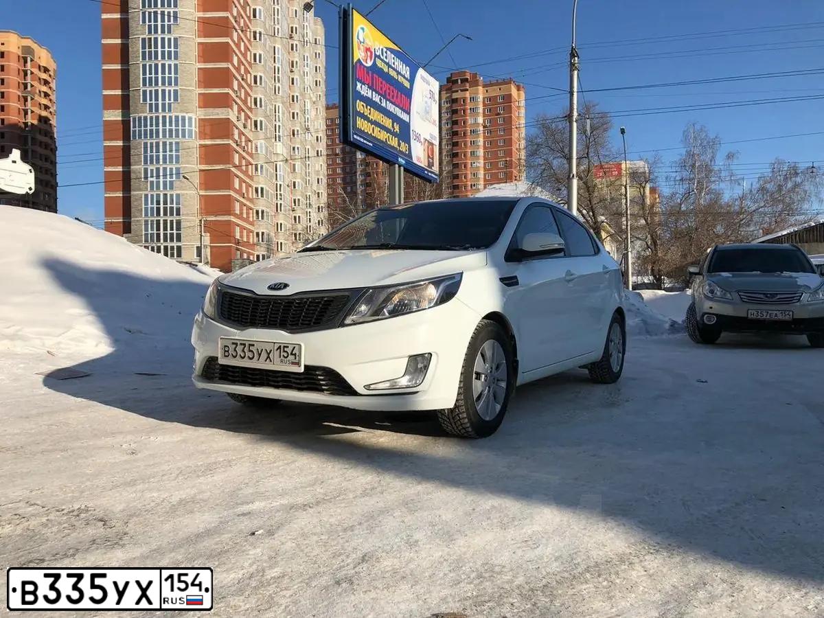 Фото автомобиля KIA RIO, 2013 — госномер В335УХ154. Цвет: Белый