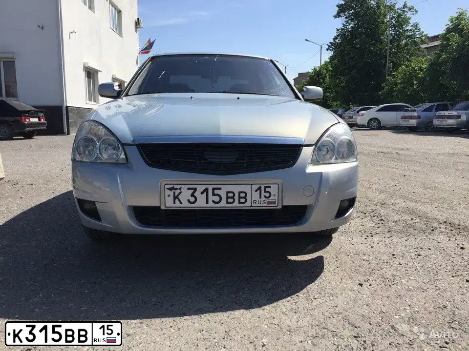 Фото автомобиля LADA 2170 PRIORA, 2007 — госномер Е064ОЕ15. Цвет: Серебристо-желто-голубой