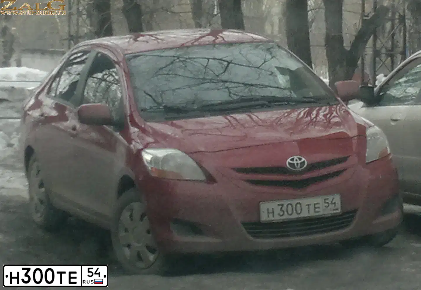 Фото автомобиля TOYOTA YARIS, 2006 — госномер Н300ТЕ54. Цвет: КРАСНЫЙ