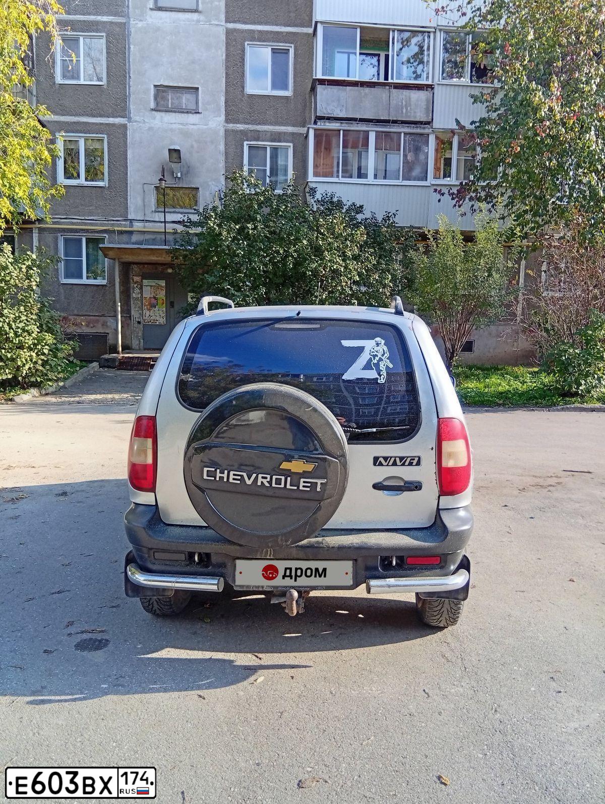 Фото автомобиля CHEVROLET NIVA, 2005 — госномер Е603ВХ174. Цвет: серебристый