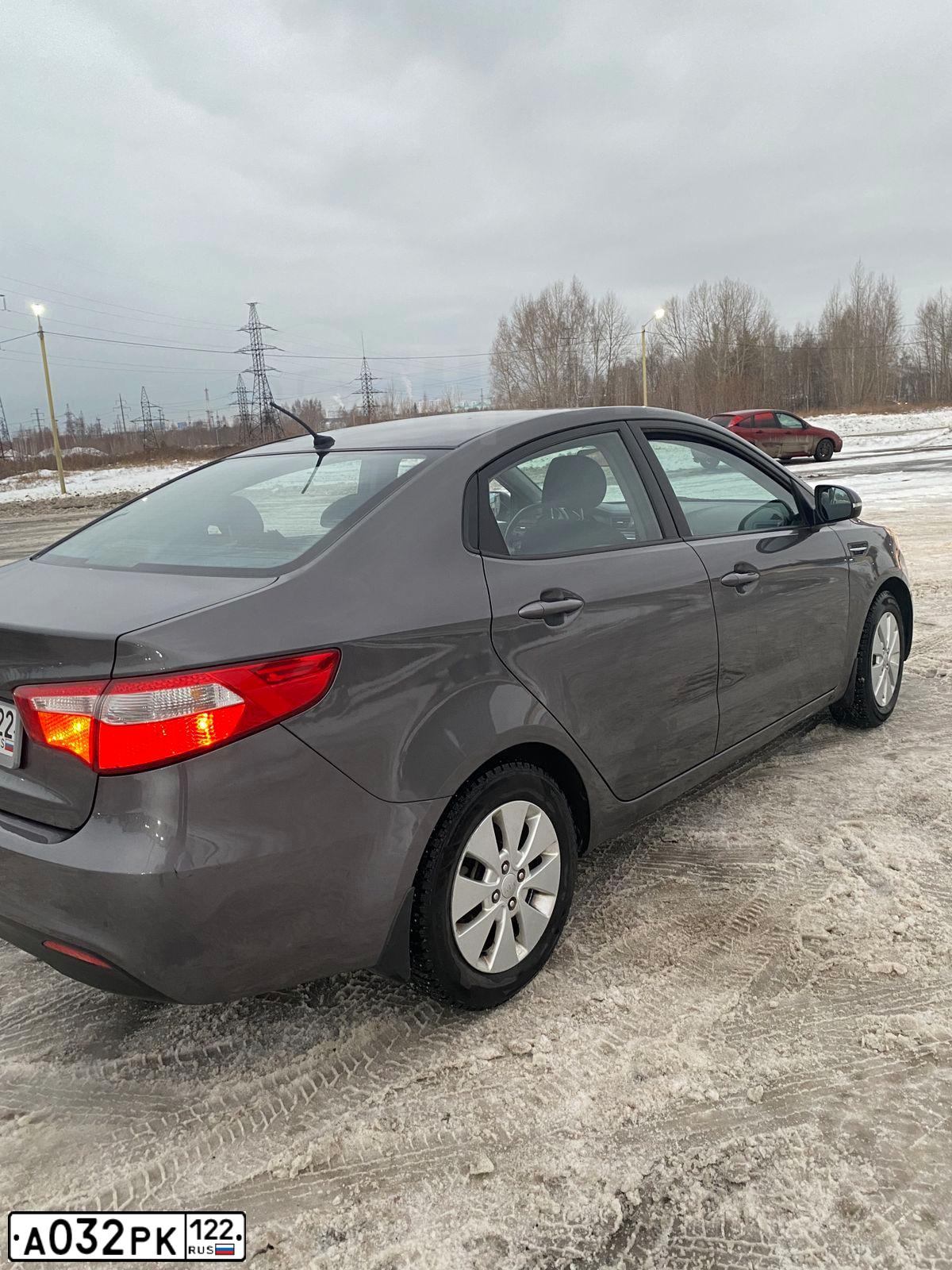 Фото автомобиля KIA RIO, 2013 — госномер Р385ЕМ154. Цвет: СЕРЫЙ