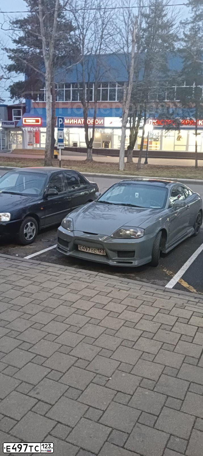 Фото автомобиля HYUNDAI /S-/COUPE / TUSCANI, 2006 — госномер Е497ТС123. Цвет: СЕРЫЙ