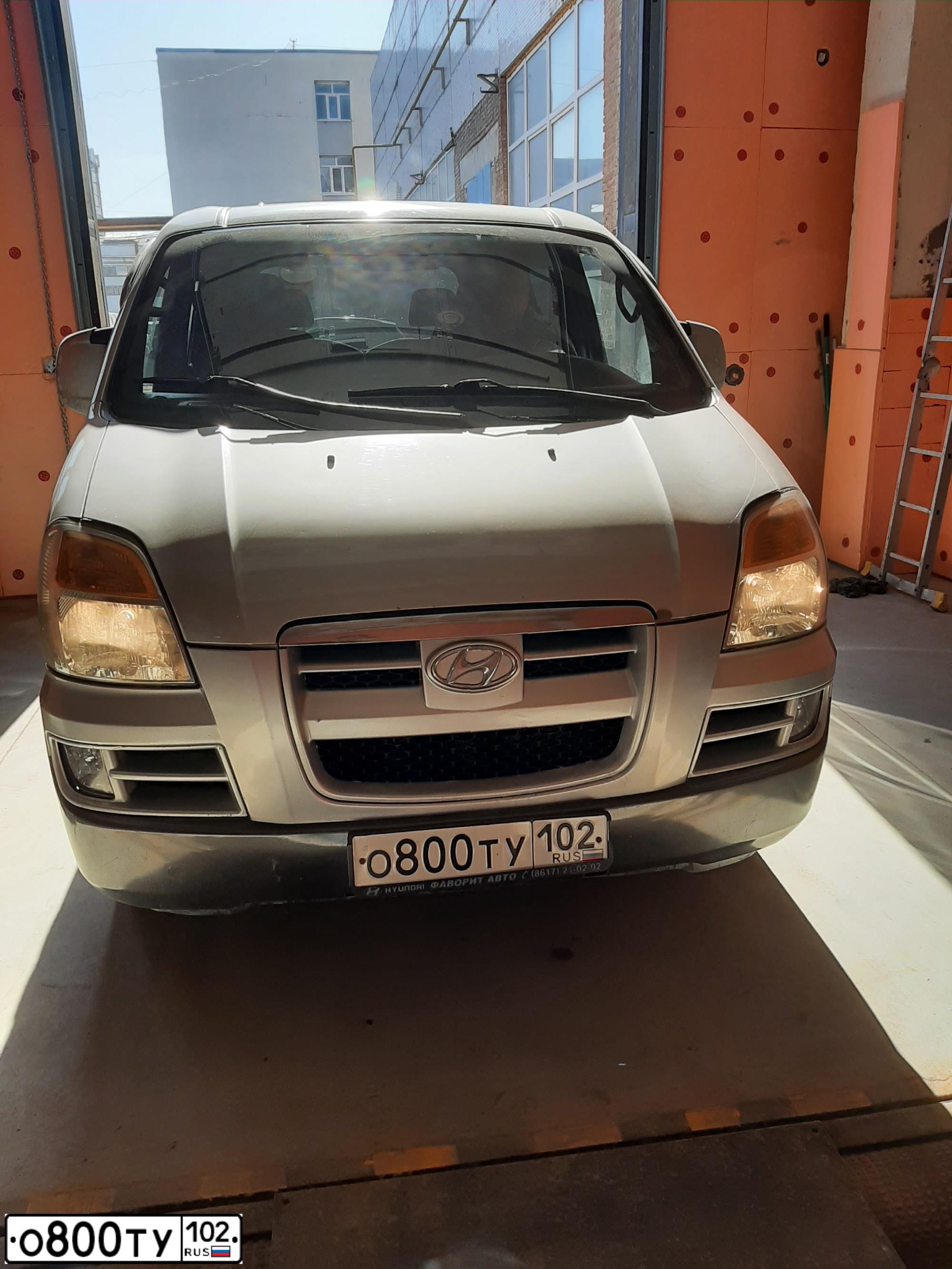 Фото автомобиля HYUNDAI H 1/H 100/STAREX, 2004 — госномер К810ТМ702. Цвет: (БЕЛЫЙ)СЕРЕБРИСТЫЙ