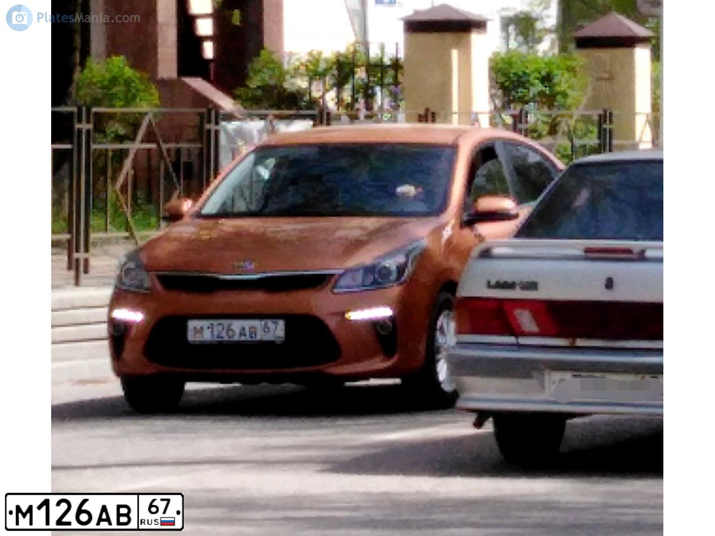 Фото автомобиля KIA RIO, 2019 — госномер М126АВ67. Цвет: ОРАНЖЕВЫЙ