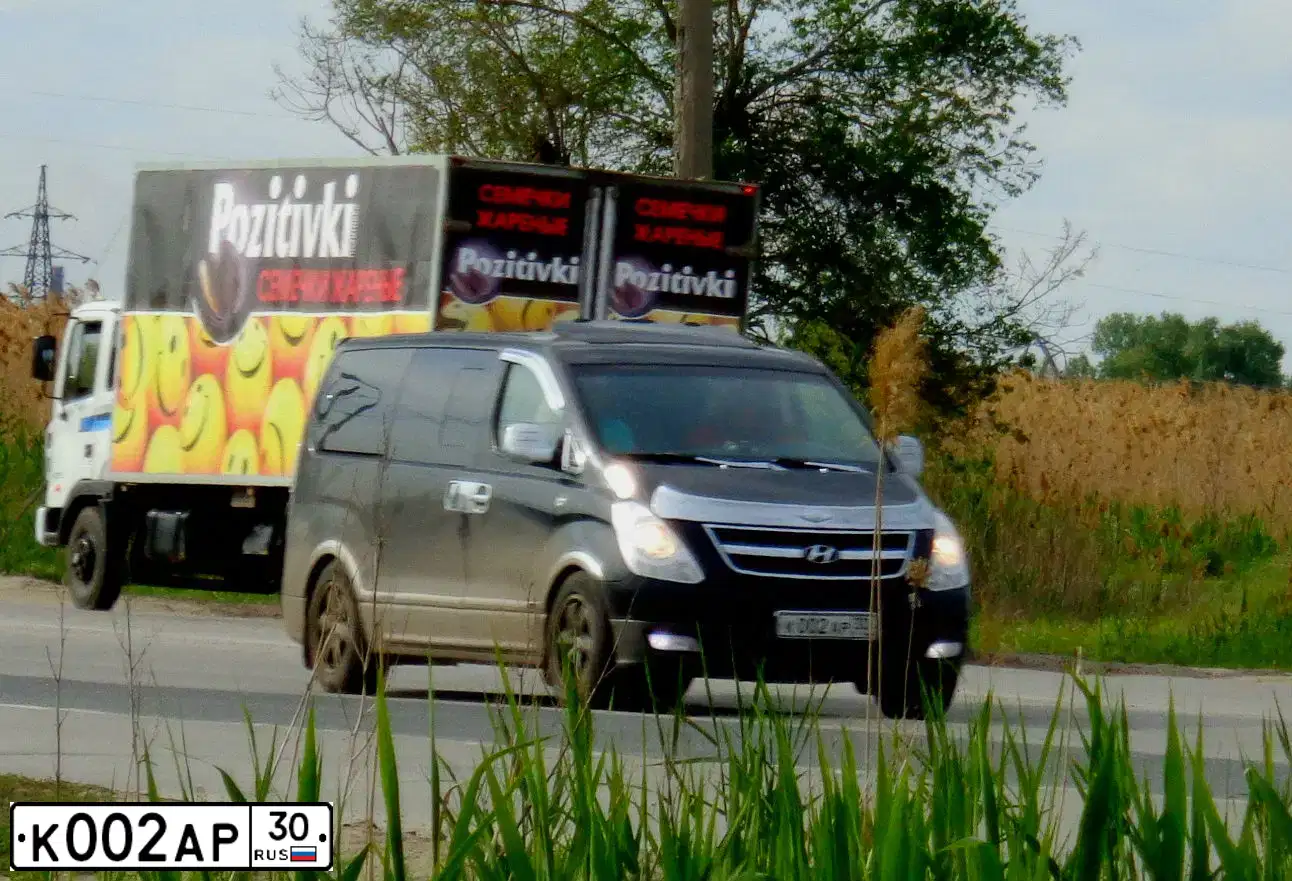 Фото автомобиля HYUNDAI GRAND STAREX, 2008 — госномер К002АР30. Цвет: ЧЕРНЫЙ