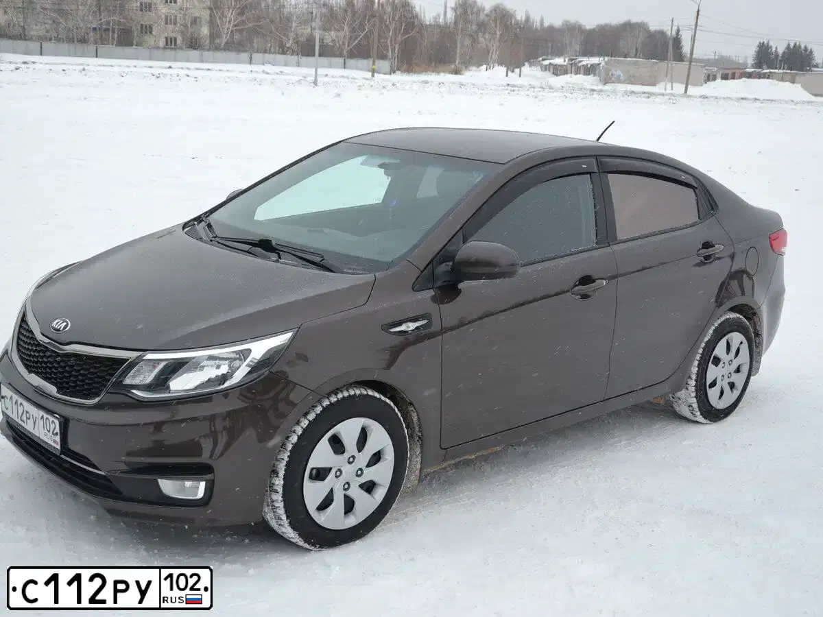 Фото автомобиля KIA RIO, 2015 — госномер О977ЕТ702. Цвет: Коричневый