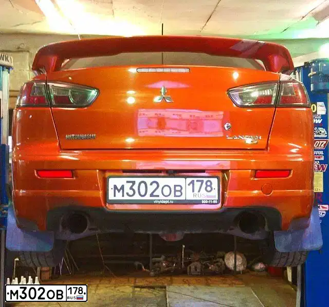 Фото автомобиля MITSUBISHI LANCER, 2009 — госномер Х106ТТ178. Цвет: ОРАНЖЕВЫЙ