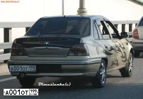 Фото автомобиля DAEWOO NEXIA, 2008 — госномер А001ОТ199. Цвет: ЗОЛОТИСТЫЙ