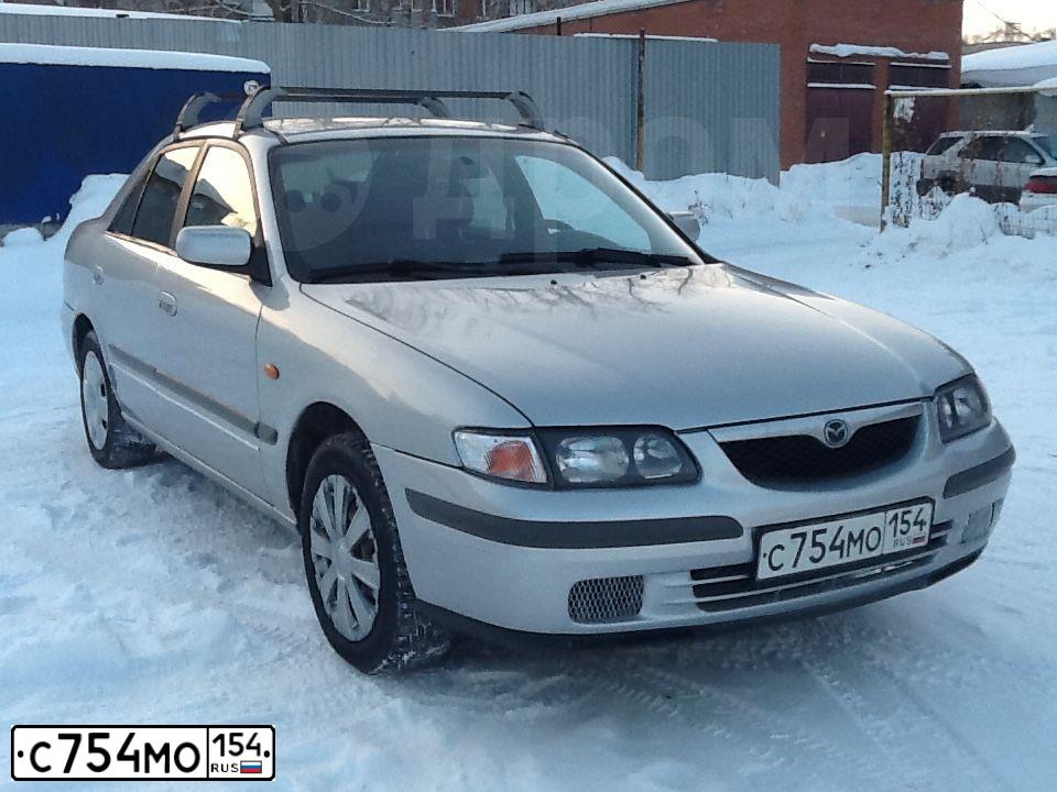 Фото автомобиля MAZDA 626, 1998 — госномер С754МО154. Цвет: БЕЛЫЙ СЕРЕБРИСТЫЙ