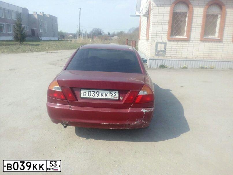 Фото автомобиля MITSUBISHI LANCER, 1997 — госномер К146КЕ53. Цвет: ВИШНЕВЫЙ