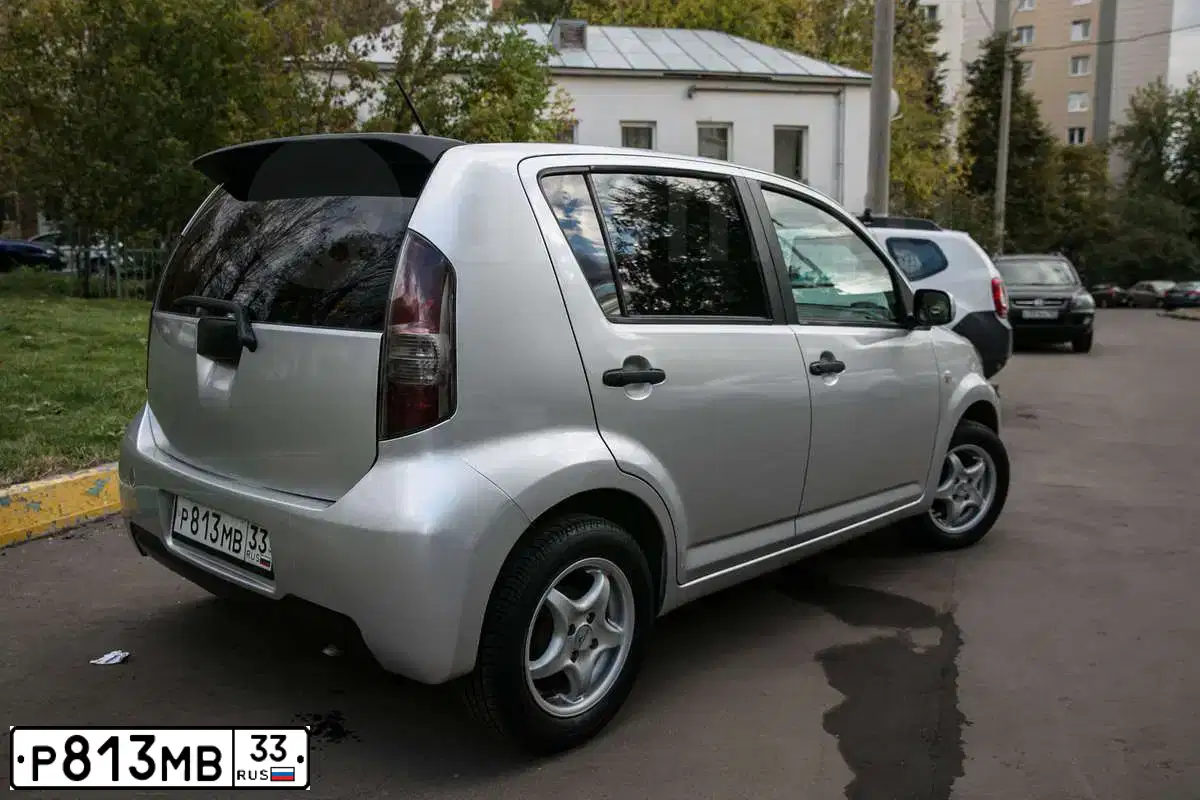 Фото автомобиля DAIHATSU SIRION, 2007 — госномер А264СР01. Цвет: СЕРЫЙ
