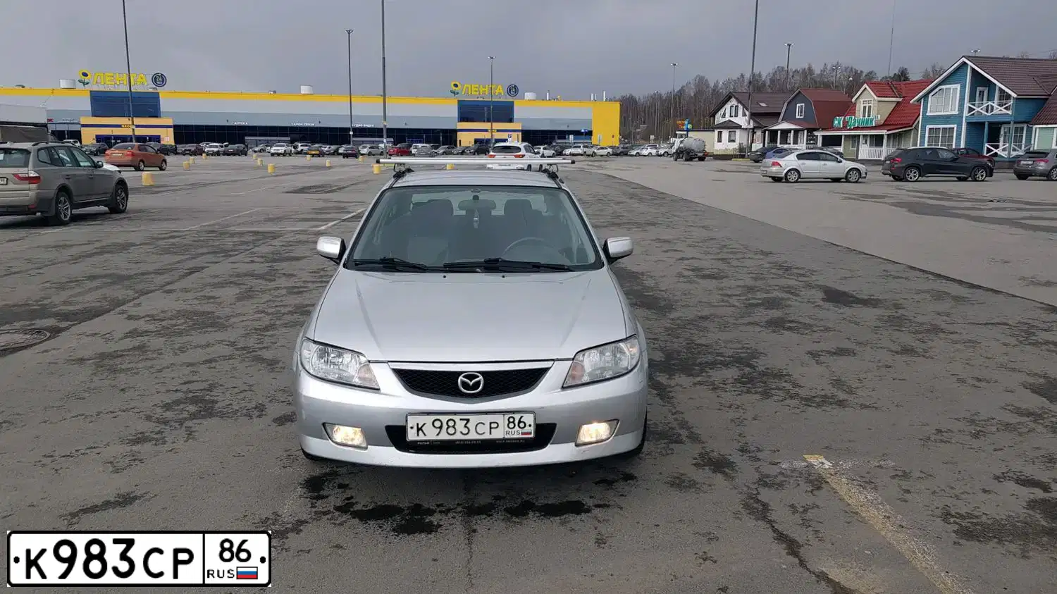 Фото автомобиля MAZDA 323, 2002 — госномер К983СР86. Цвет: Серебристый