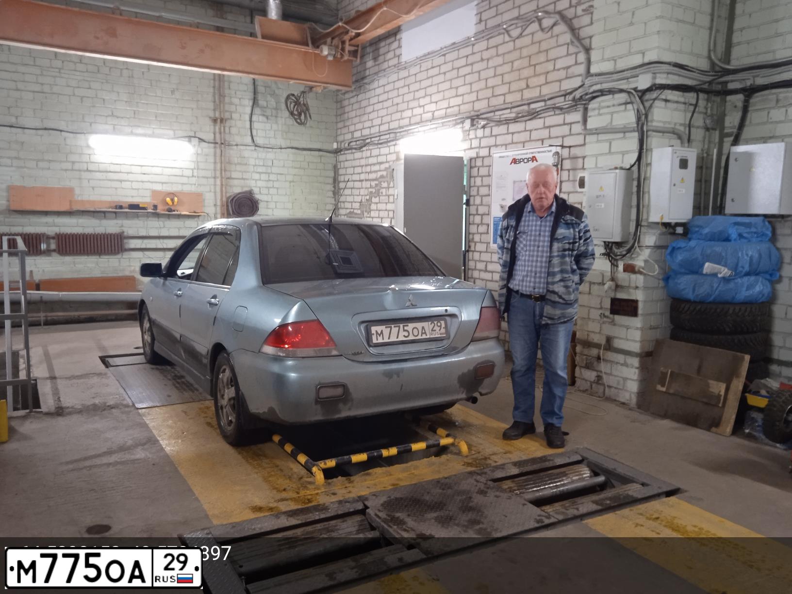 Фото автомобиля MITSUBISHI LANCER, 2006 — госномер М775ОА29. Цвет: СВЕТЛО СЕРО-ЗЕЛЕНЫЙ