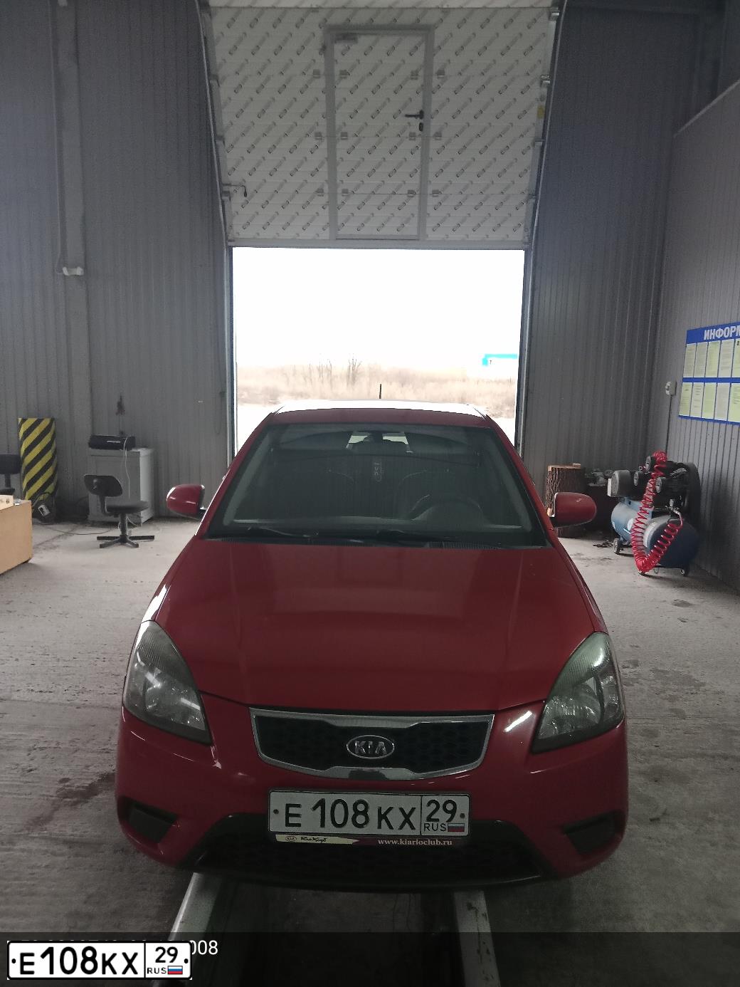 Фото автомобиля KIA RIO, 2009 — госномер Е108КХ29. Цвет: Красный