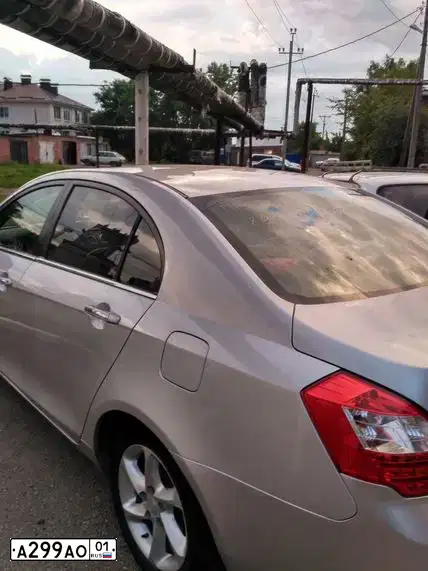Фото автомобиля GEELY EMGRAND, 2012 — госномер А299АО01. Цвет: СЕРЕБРО