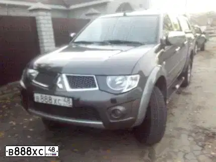 Фото автомобиля MITSUBISHI L 200, 2012 — госномер В990УТ702. Цвет: Коричневый