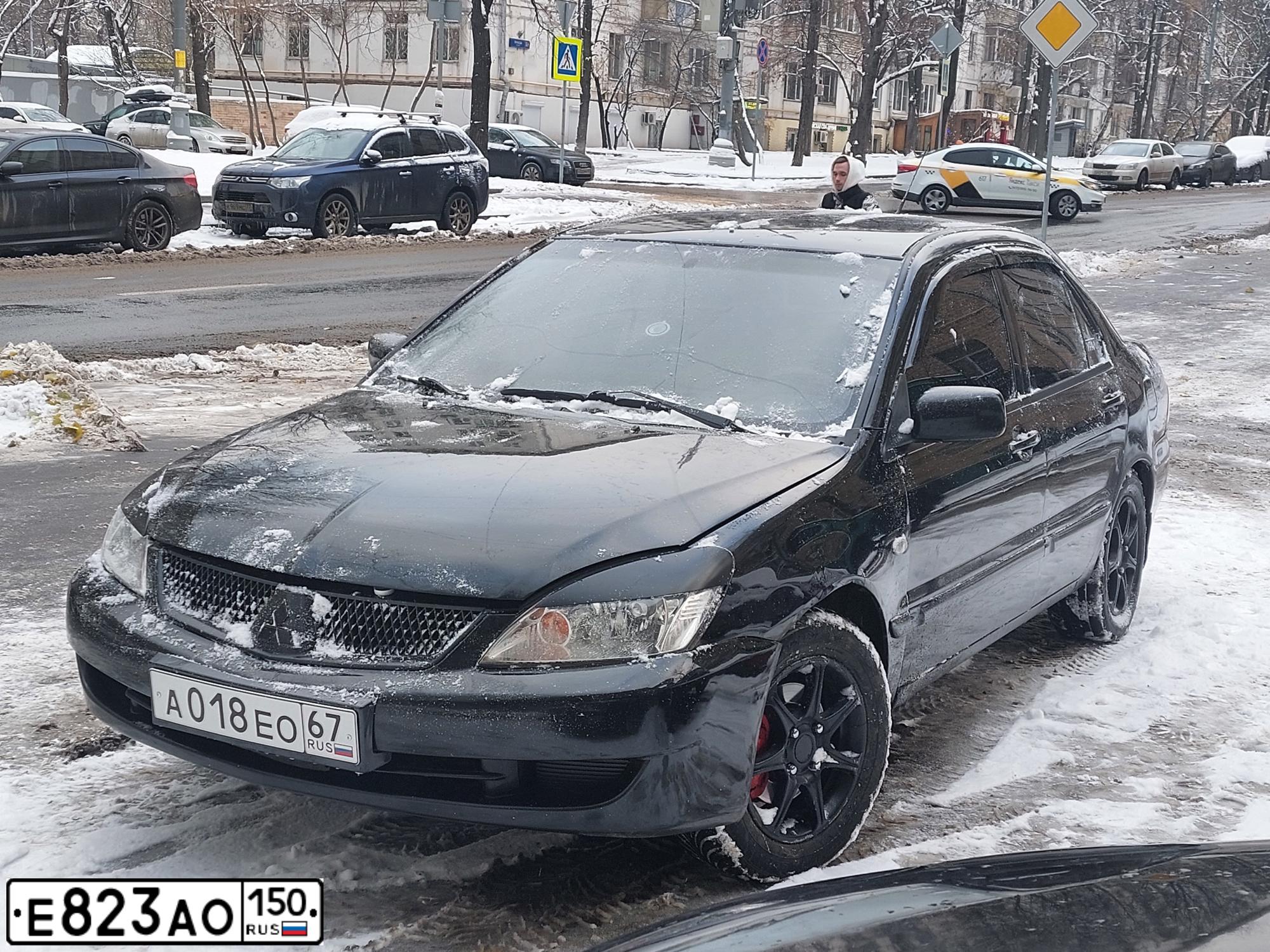 Фото автомобиля MITSUBISHI LANCER, 2005 — госномер А018ЕО67. Цвет: ЧЕРНЫЙ