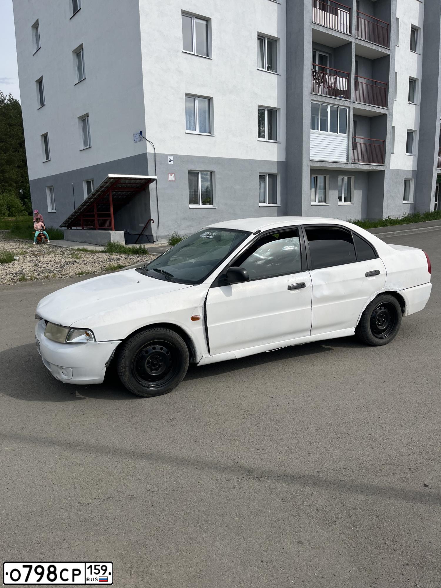 Фото автомобиля MITSUBISHI LANCER, 1998 — госномер О798СР159. Цвет: Белый