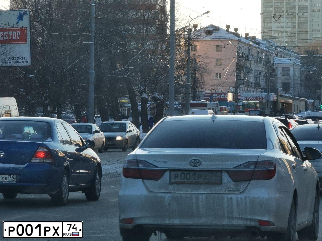 Фото автомобиля TOYOTA CAMRY, 2018 — госномер Р001РХ74. Цвет: БЕЛЫЙ ПЕРЛАМУТР