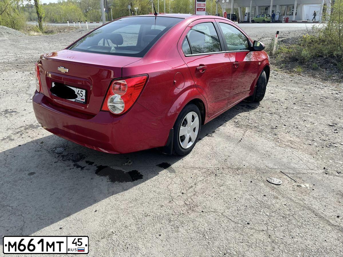 Фото автомобиля CHEVROLET AVEO, 2013 — госномер Х110МР45. Цвет: КРАСНЫЙ МЕТАЛЛИК