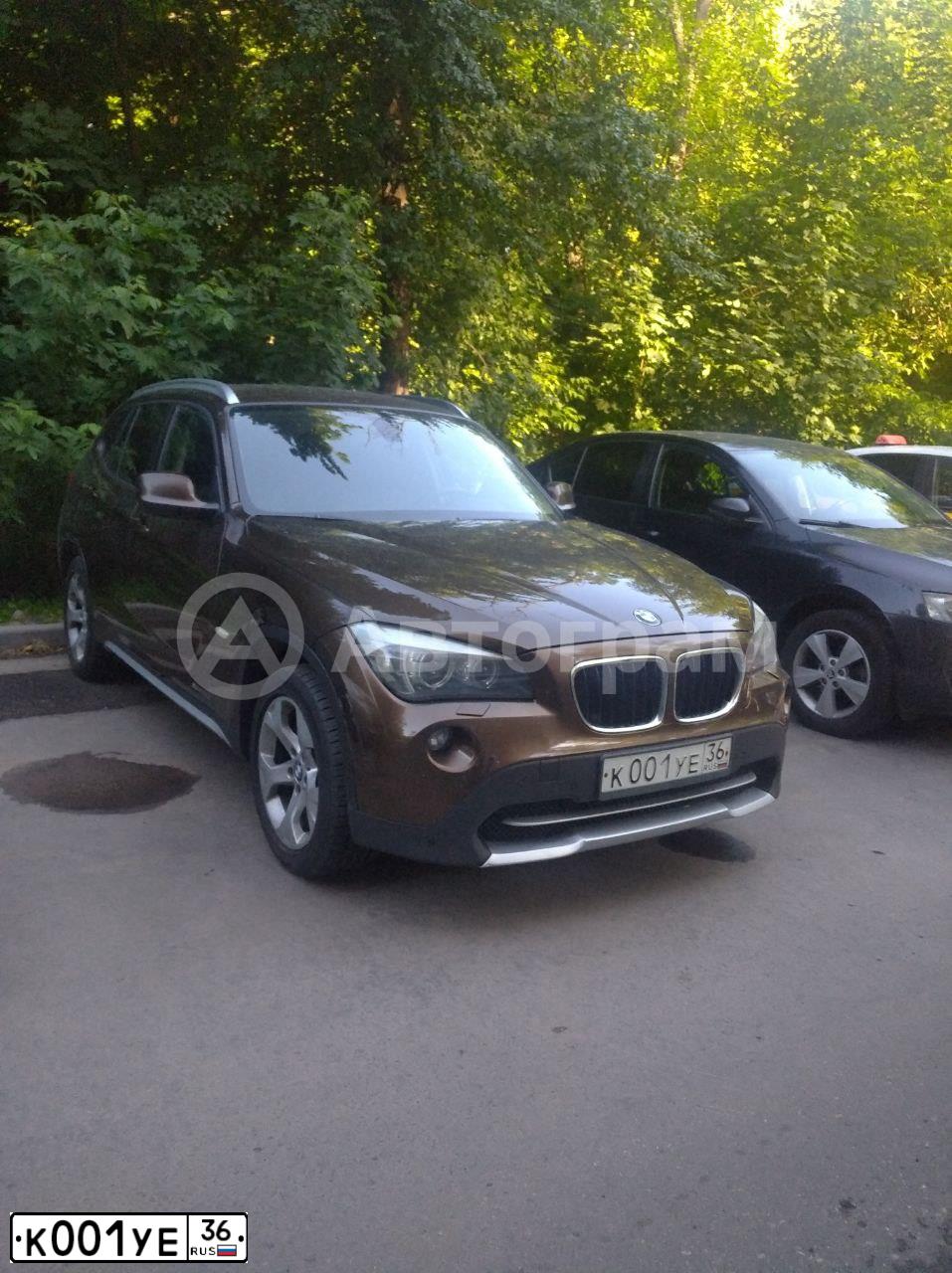 Фото автомобиля BMW X1, 2012 — госномер К001УЕ36. Цвет: КОРИЧНЕВЫЙ